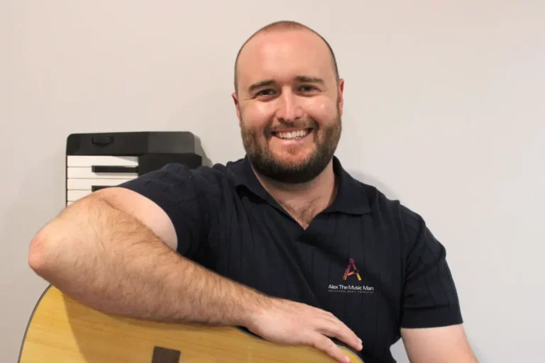 Alex from Alex the Music Man, registered music therapist, with his guitar