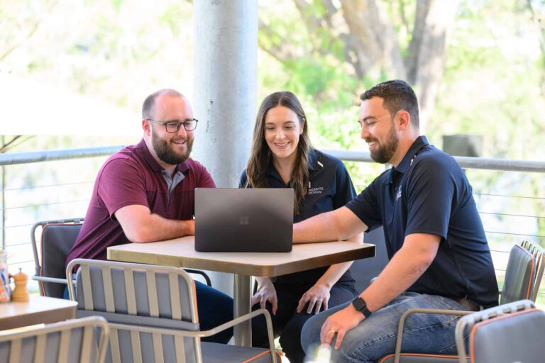 Jordan and Simone from JS Website Design reviewing a website on a laptop with a client