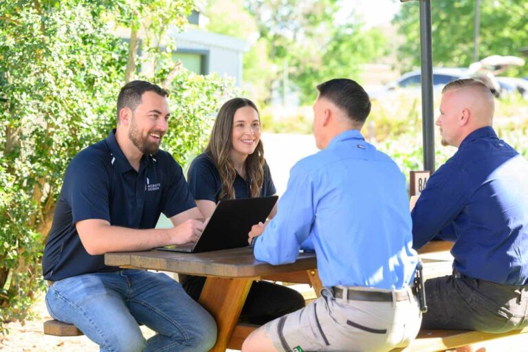 Jordan and Simone from JS Website Design talking with a client at an outdoor table