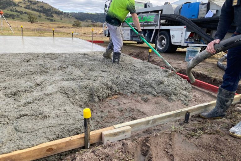 Concrete being poured and spread inside timber formwork