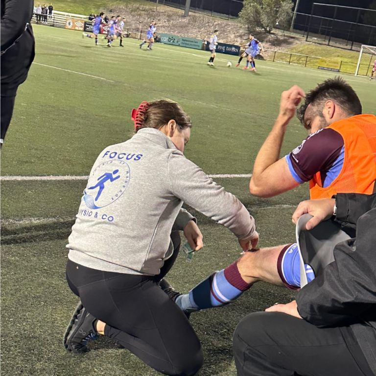 Focus Physio and Co physiotherapist treating a player on the sideline