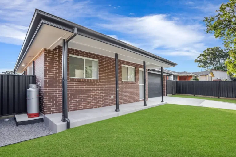 Side view of a new brick granny flat with a covered verandah