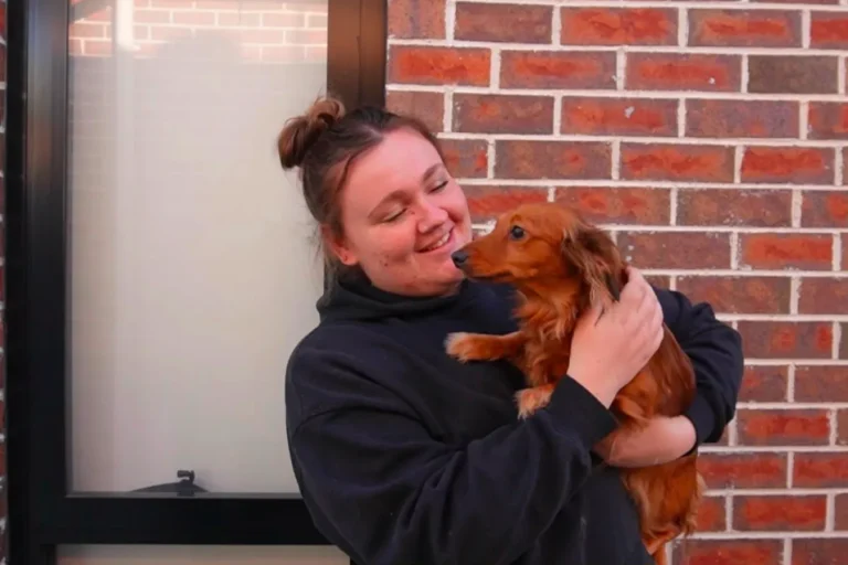 Smiling with a pet dog at an Insite Care home