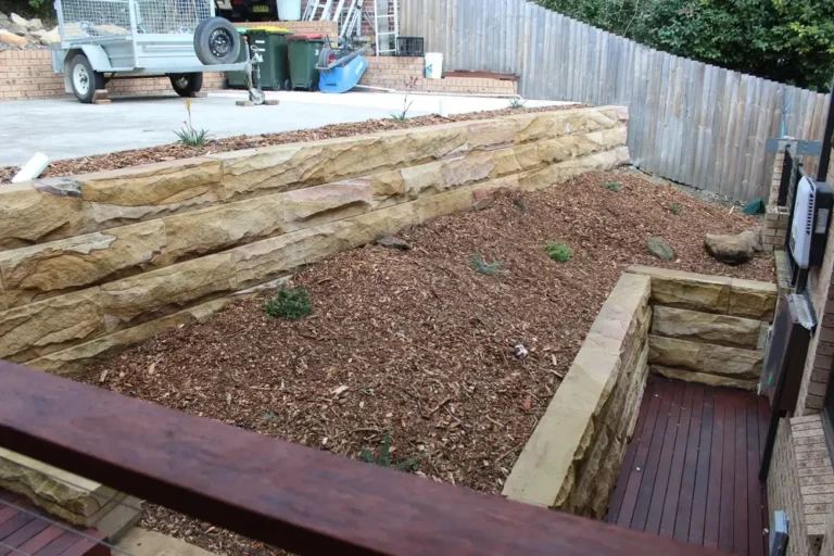 Two tiers of sandstone block retaining walls in a Blaxland front yard