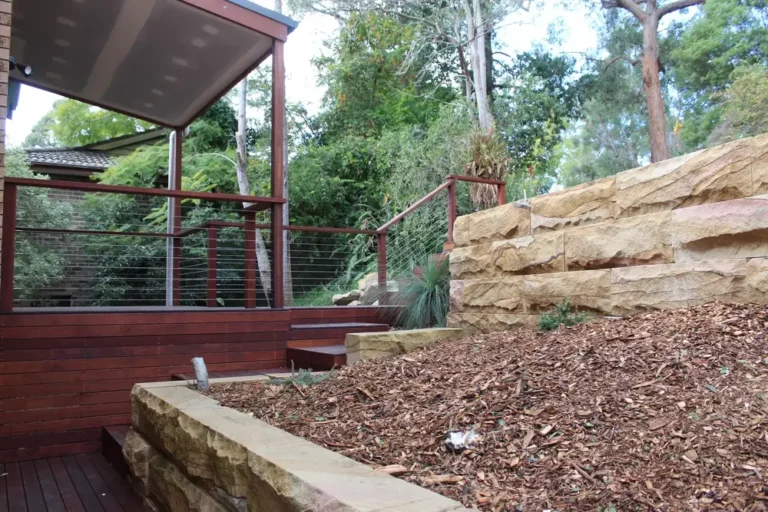 Sandstone block retaining walls and garden beds beside a deck in Blaxland