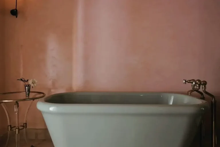 Terracotta-toned Venetian plaster wall behind a freestanding bath in Darling Point