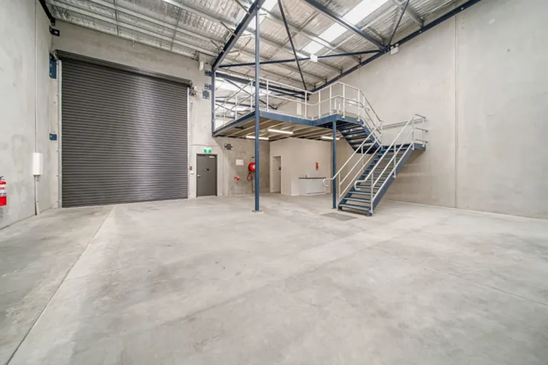 Inside a finished tilt-up warehouse unit with mezzanine stairs